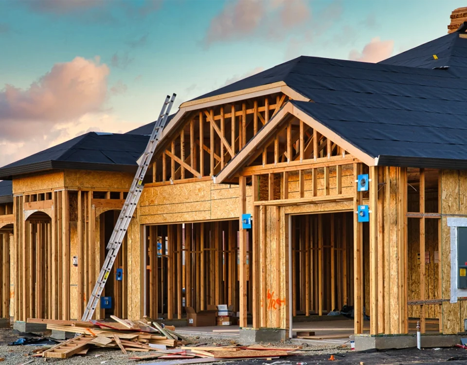 How to Build a House — wood wall framing and roof trusses going up