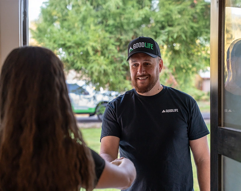 Good Life Construction worker greeting a homeowner at the front door